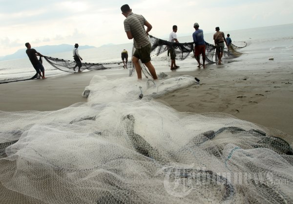 tarek pukat warga alue naga di pesisir pantai